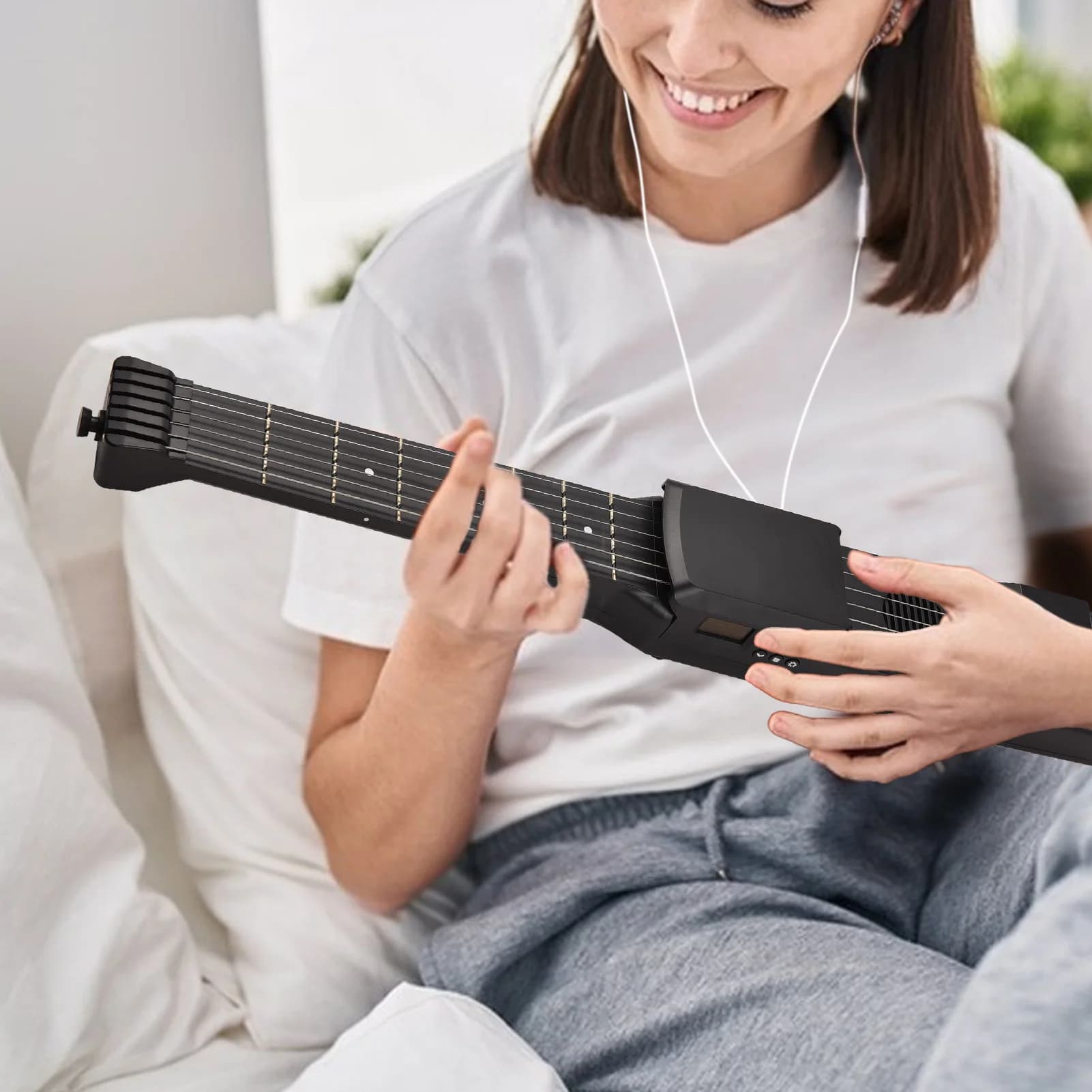 Mulher tocando uma guitarra elétrica preta com 7 trastes em um sofá