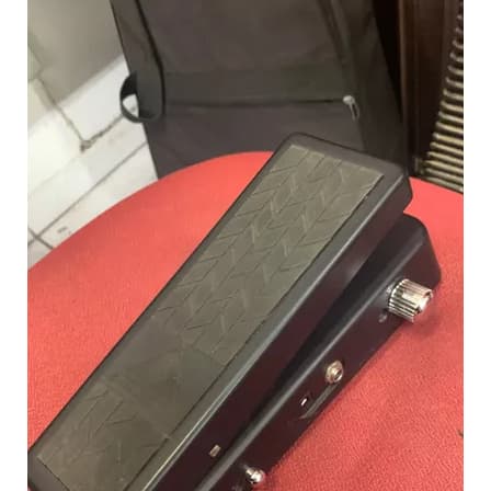 Pedal de guitarra preto com superfície texturizada sobre fundo vermelho