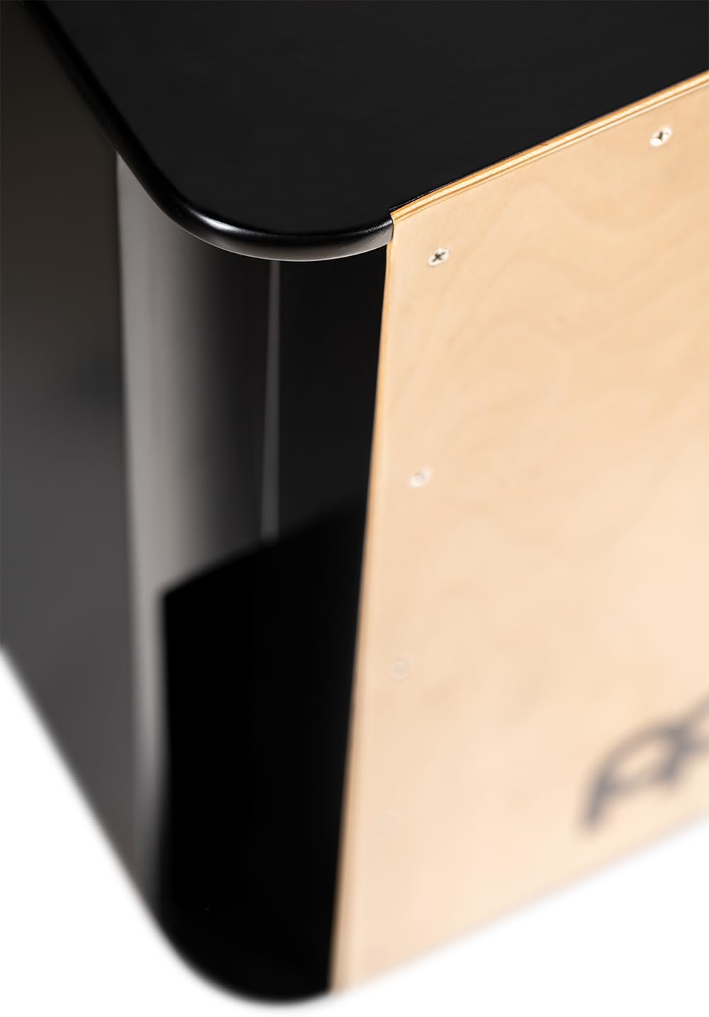 Close em canto arredondado do cajon Meinl com face clara de bétula e corpo preto brilhante