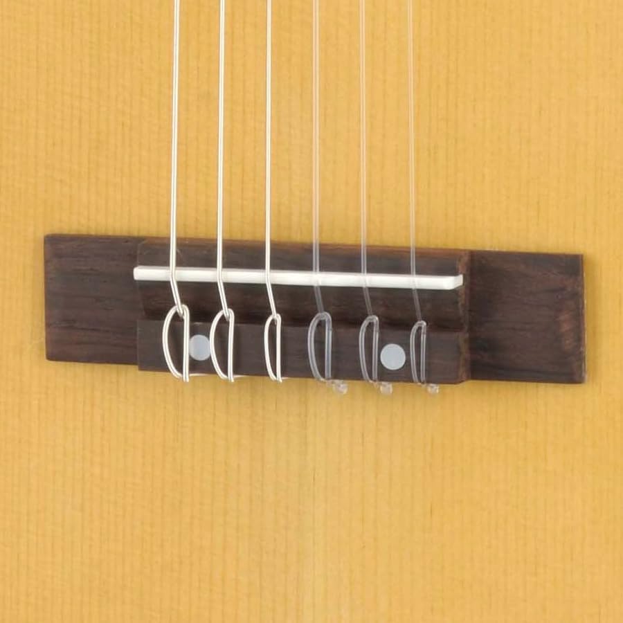 Detalhe do cavalete em madeira escura da Yamaha GL-1 Guitalele com cordas de nylon amarradas.