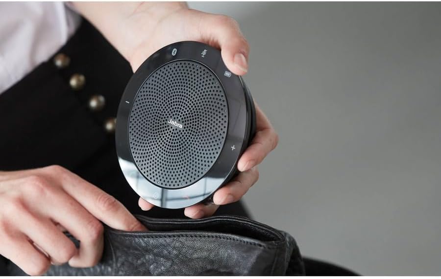 Pessoa guardando Jabra Speak 510 porta voz Bluetooth em bolsa preta, mostrando portabilidade e tamanho compacto.