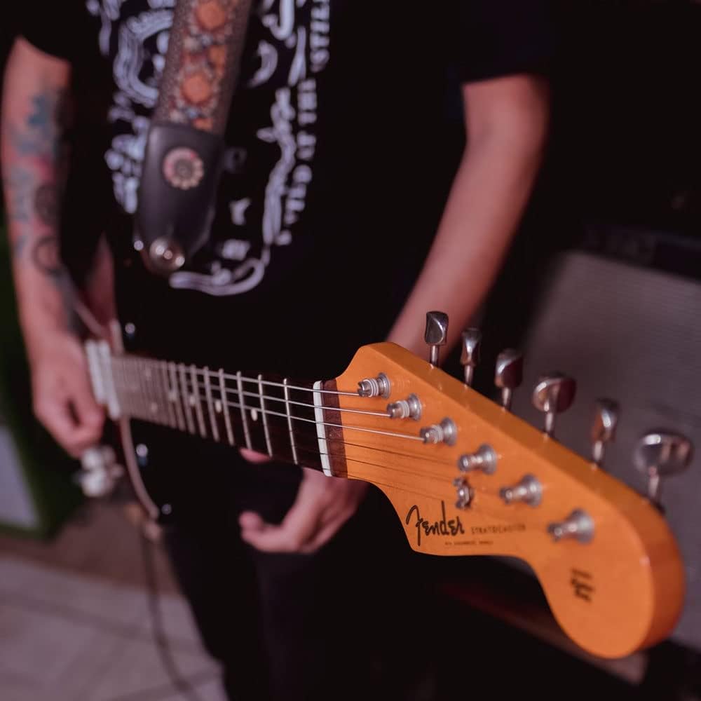 Pessoa segurando guitarra Squier Classic Vibe '70s Stratocaster HSS preta com braço maple e cabeçote Fender.