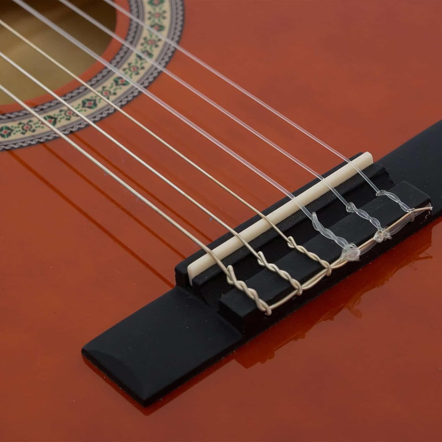 Close no cavalete e cordas de nylon do violão infantil Giannini 1/4 acústico