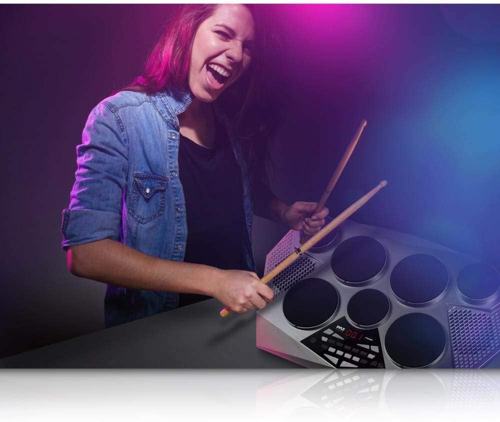 Mulher tocando bateria eletrônica portátil Pyle PTED06 com baquetas