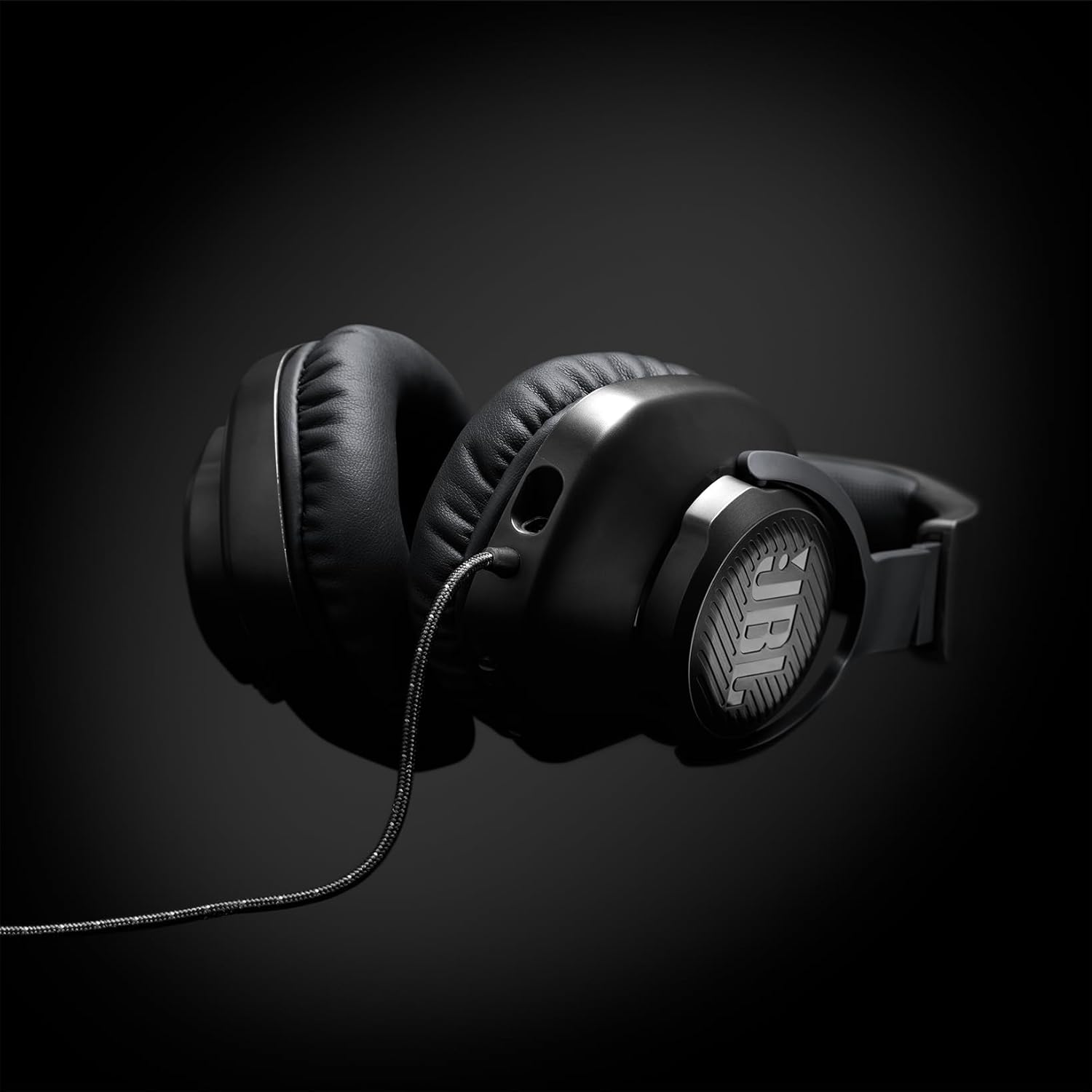 Headset JBL Quantum 100 preto com cabo trançado em fundo preto com iluminação destacada