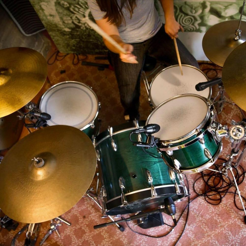 Baterista tocando bateria com microfones Shure PGA56 instalados no kit para gravação de som