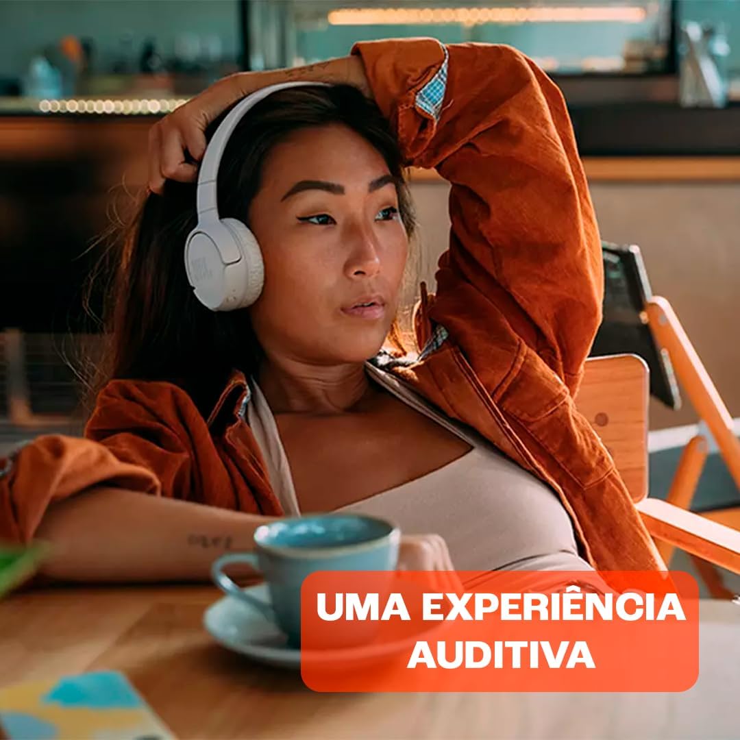 Mulher relaxando usando fones JBL Tune 520BT branco, proporcionam uma experiência auditiva confortável