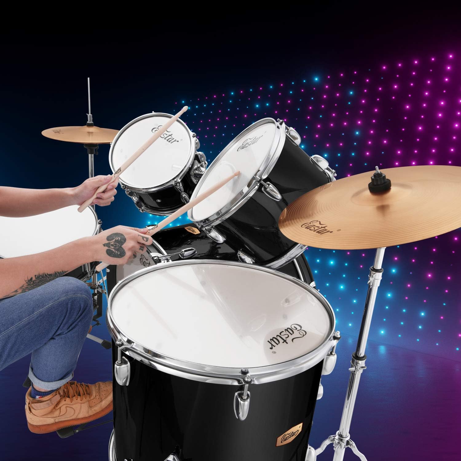 Pessoa tocando bateria Eastar preta espelhada em ambiente com iluminação colorida.