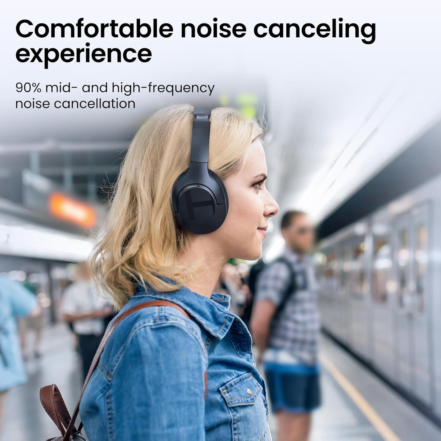 Mulher usando fones Haylou S35 com cancelamento de ruído confortável e alta eficácia em estações de metrô.