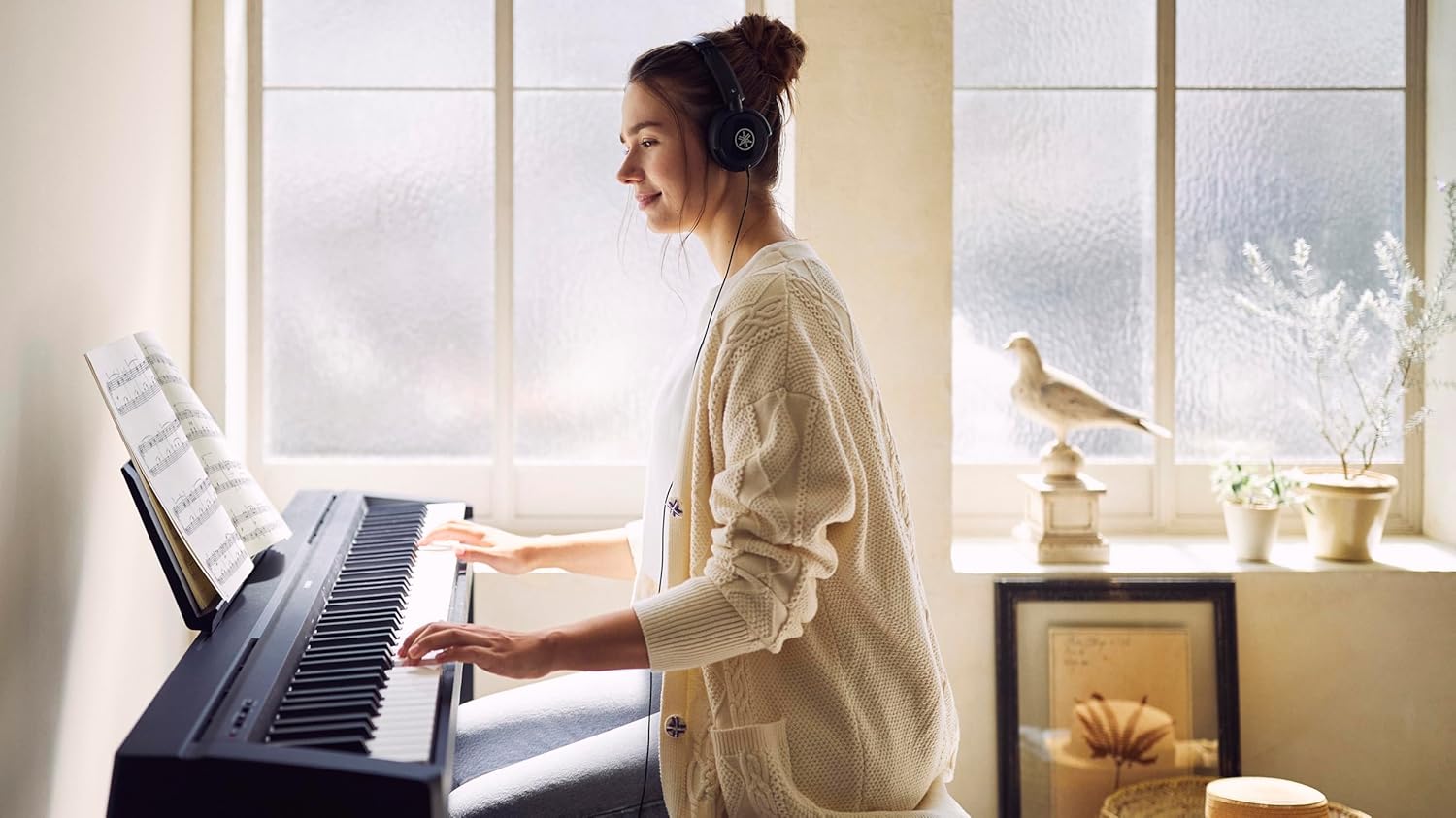Mulher tocando piano digital Yamaha P-45 com fones de ouvido em ambiente iluminado.