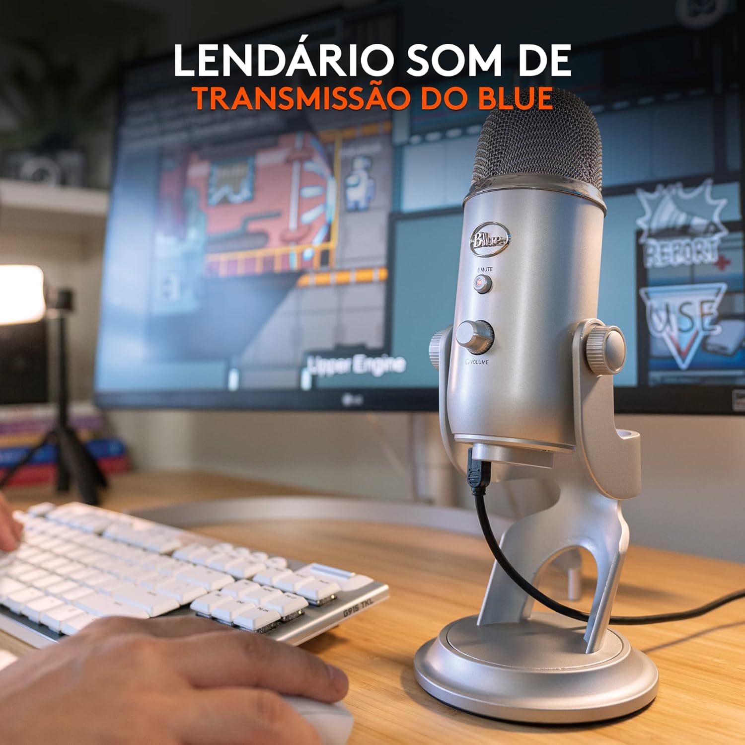Microfone USB Blue Yeti prateado da Logitech com texto promocional e monitor ao fundo