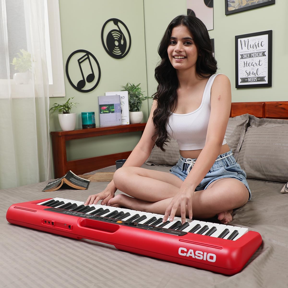 Pessoa tocando teclado musical Casio CT-S200Rdc2 vermelho em ambiente caseiro decorado