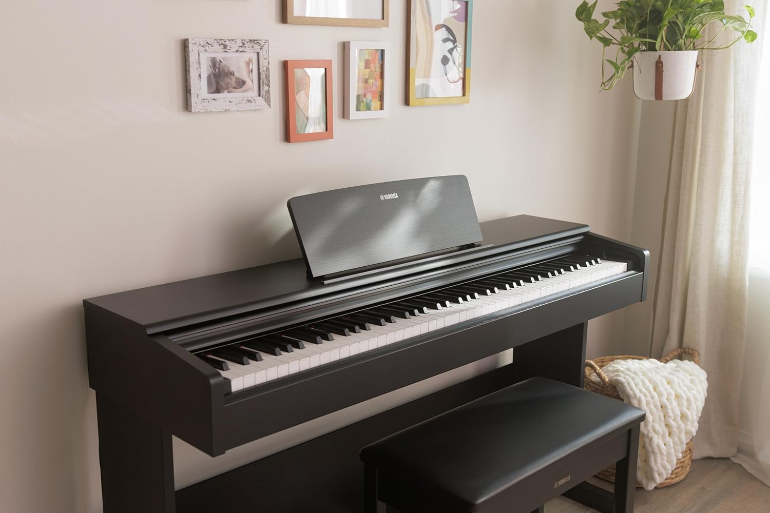 Piano digital Yamaha preto em ambiente iluminado com banco e decoração