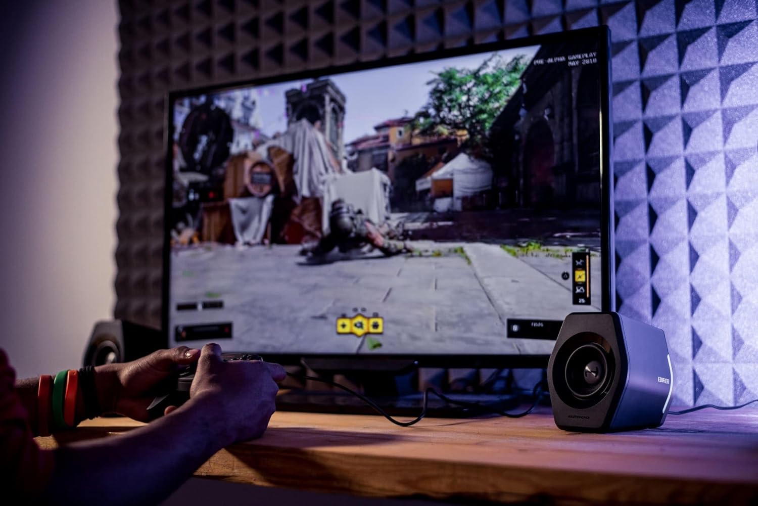 Caixas de som gamer Edifier G2000 em setup de jogo com TV e controlador.