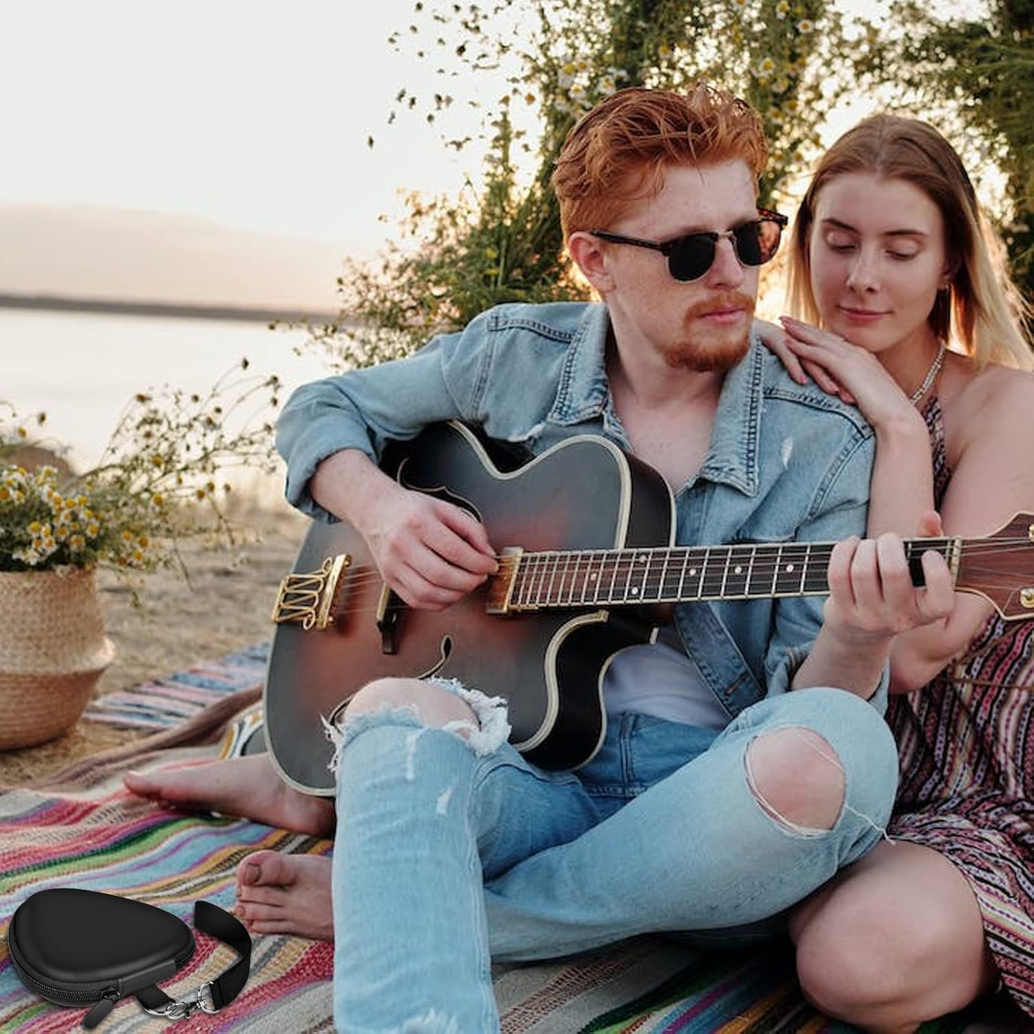 Estojo triangular preto para palhetas ao ar livre próximo a músico tocando violão.