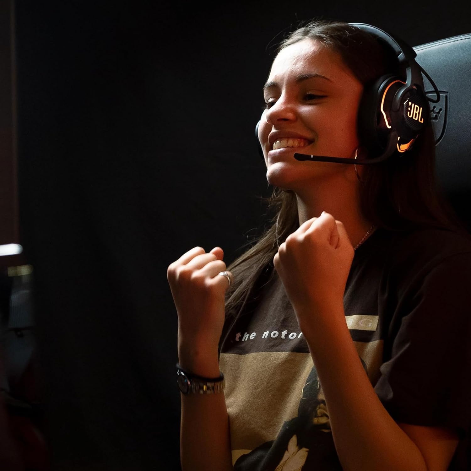 Pessoa usando headset gamer JBL Quantum 910 com microfone e iluminação RGB