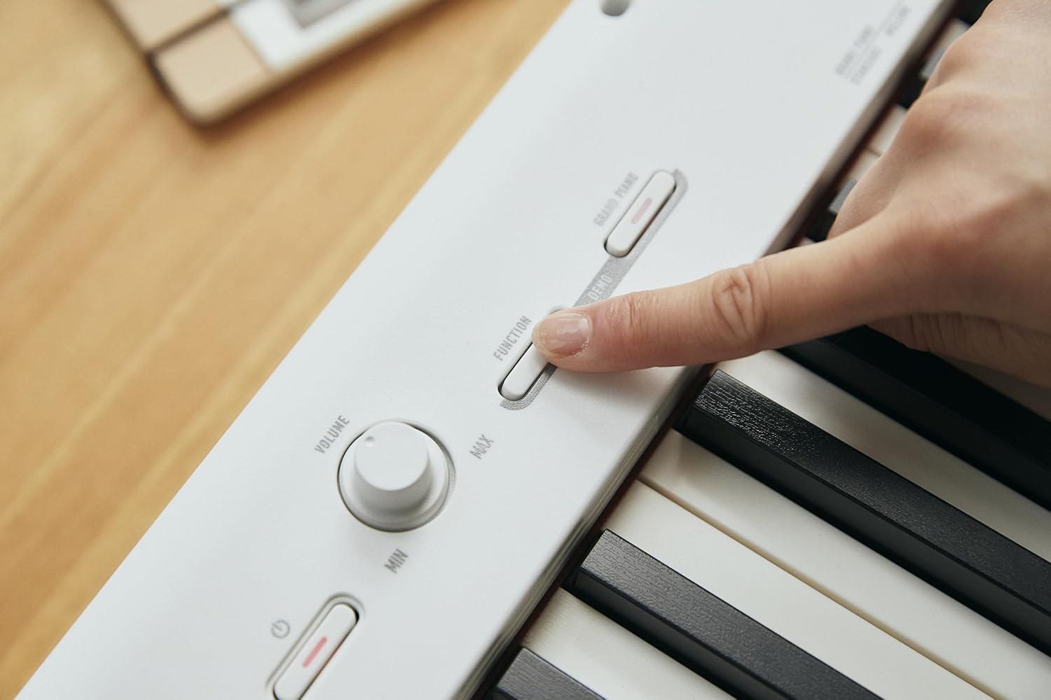 Detalhe das mãos usando controles do piano digital Casio Casiotone CDP-S110 branco.