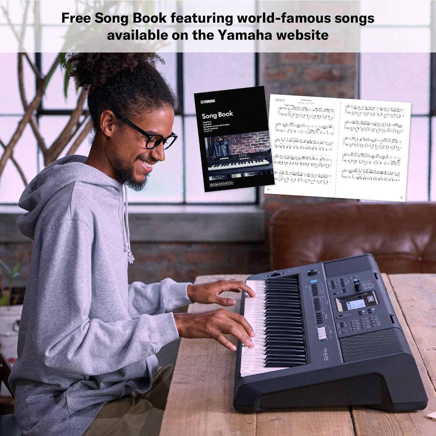 Pessoa tocando teclado Yamaha PSR E473 com destaque para livro de músicas gratuito disponível online