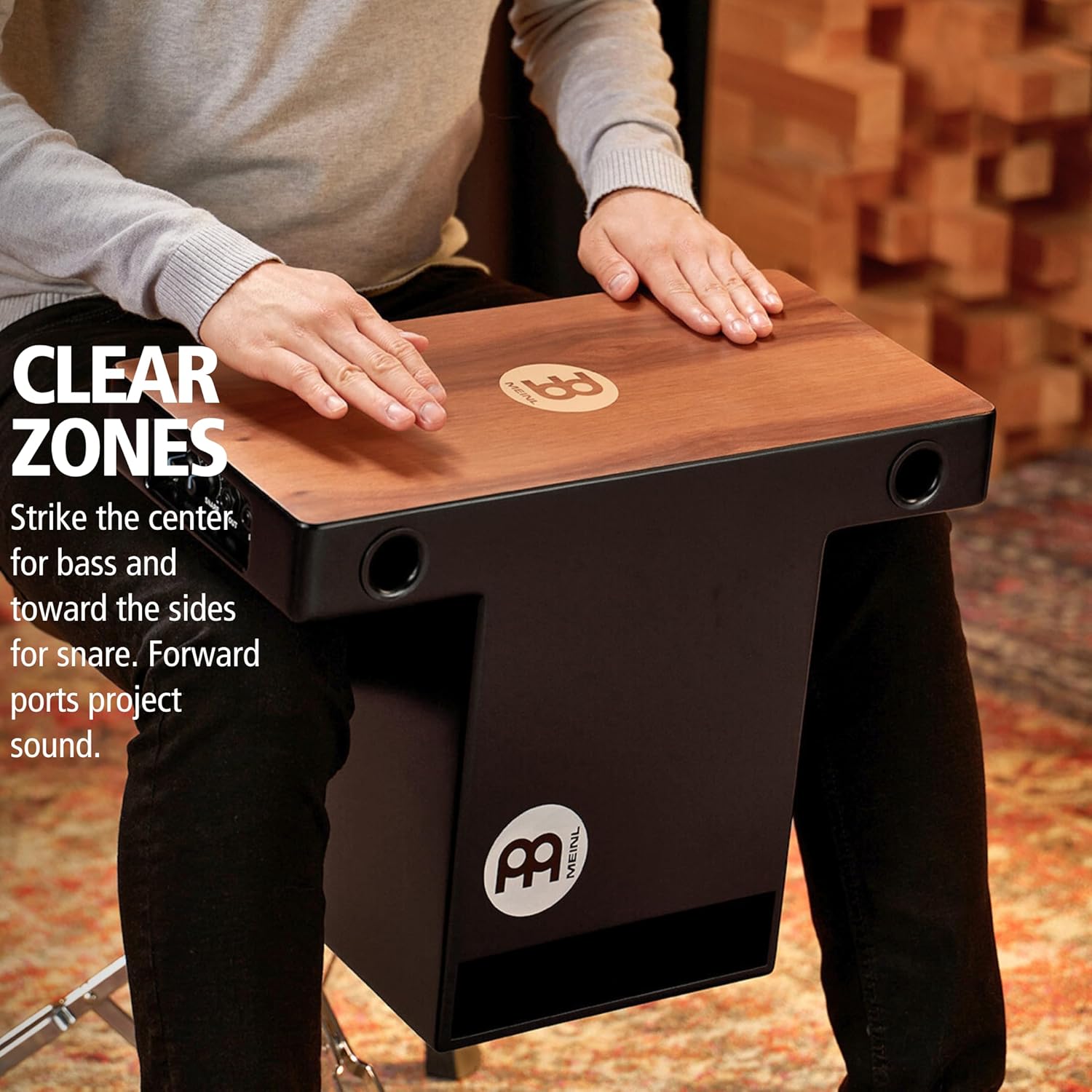 Pessoa tocando cajon Meinl PTOPCAJ2WN com zonas de toque diferenciadas para bass e snare e saída frontal de som