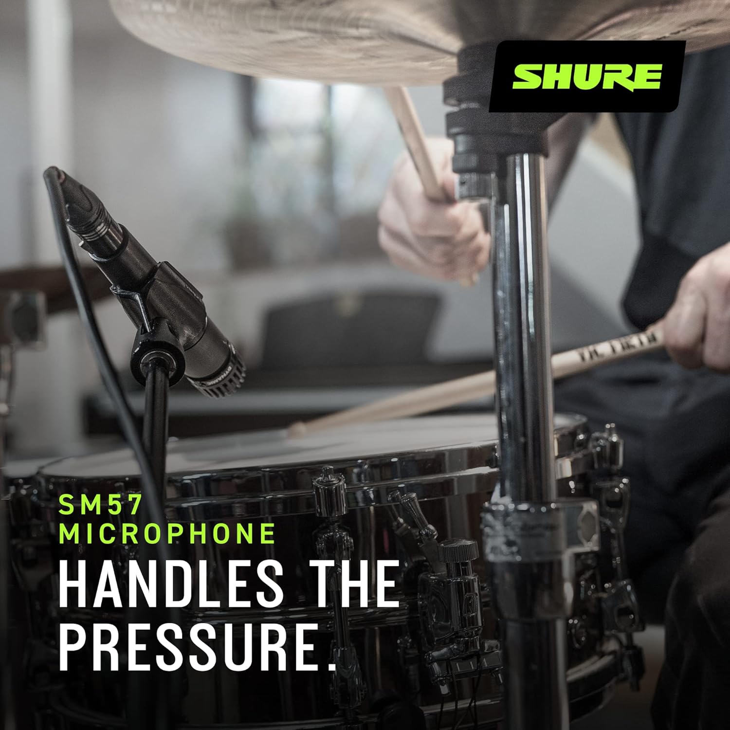 Microfone Shure SM57-LC próximo a bateria com texto 'Handles the pressure'