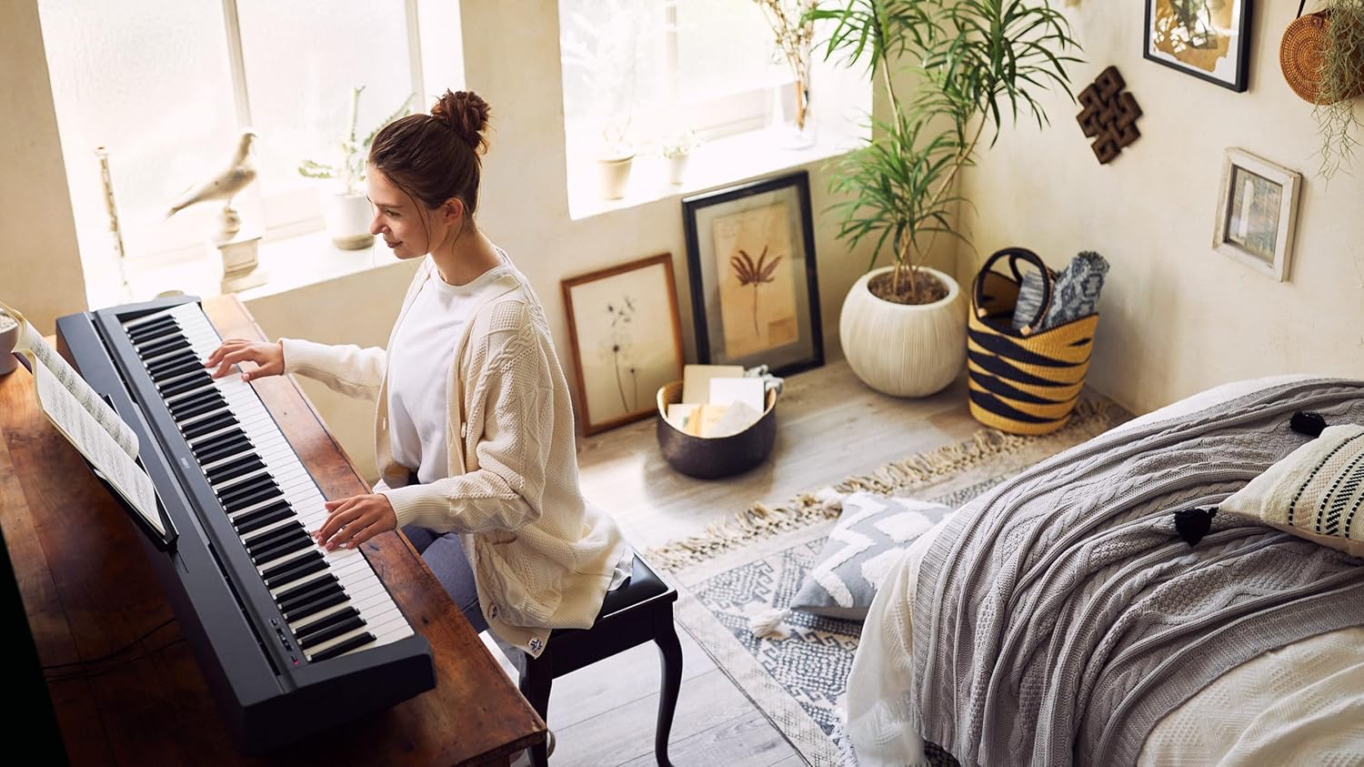 Mulher tocando Yamaha P-45B piano digital portátil preto com teclado GHS em ambiente doméstico