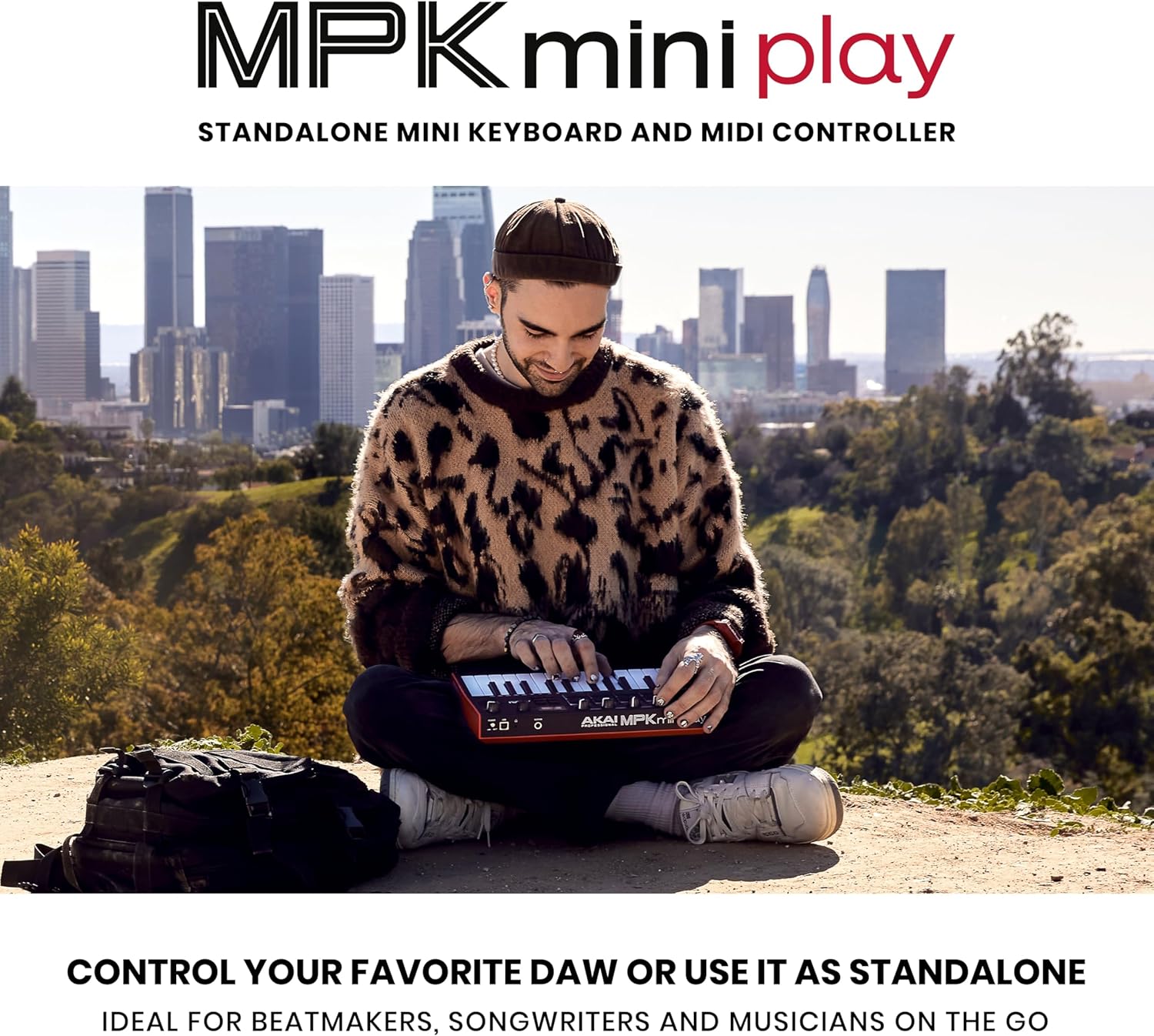 Homem usando teclado MIDI Akai MPK Mini Play MK3 ao ar livre com skyline urbano ao fundo.