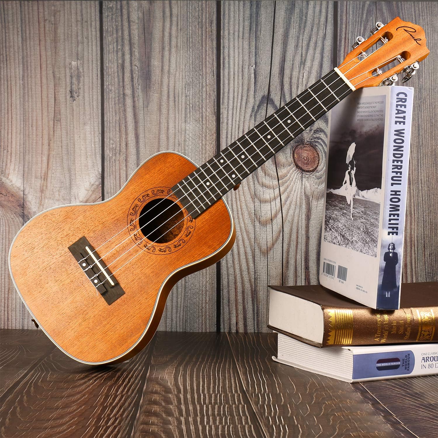 Ukulele Ranch de concerto inclinado contra livros com fundo de madeira clara