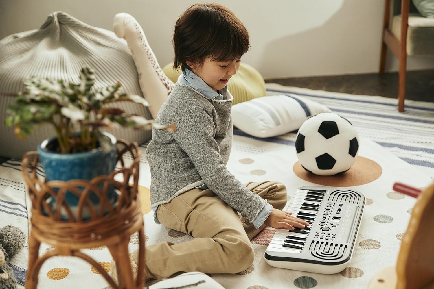 Criança tocando teclado Casio SA-51 H2 portátil preto com 32 teclas em ambiente doméstico.