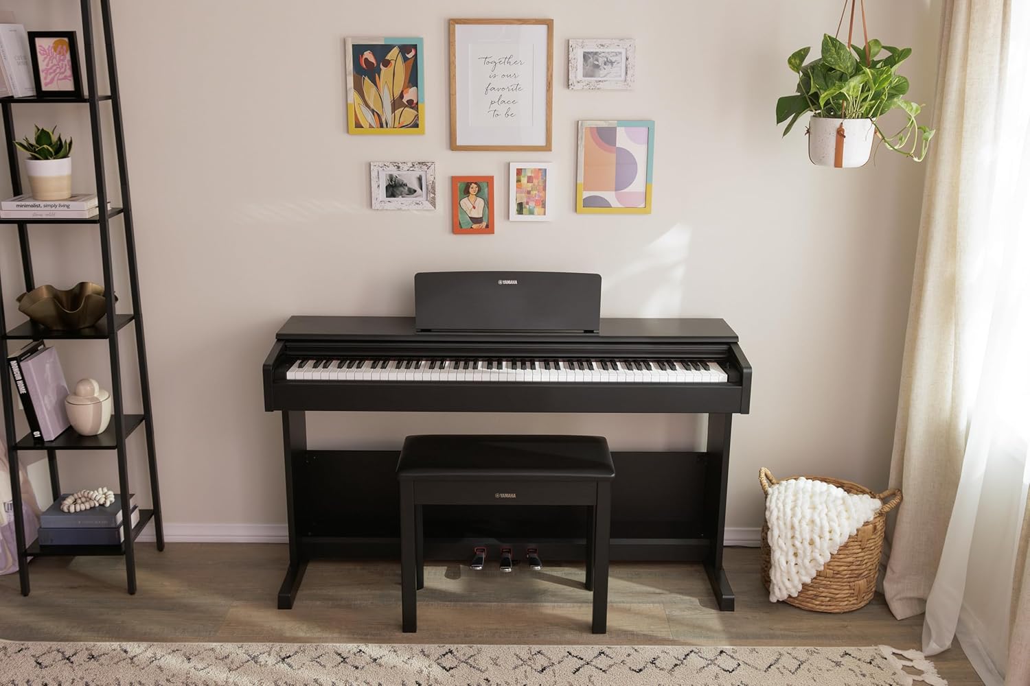 Piano digital Yamaha preto em ambiente decorado com quadros e planta