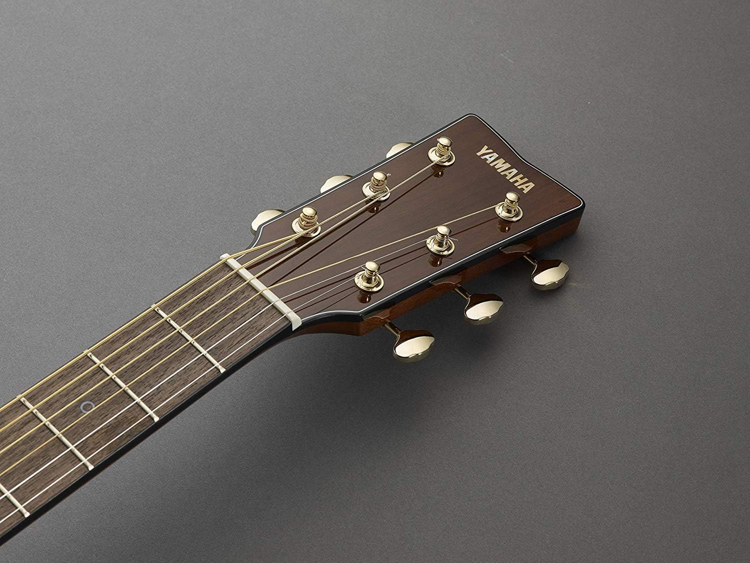 Headstock do violão Yamaha STORIA III marrom chocolate com tarraxas douradas e logo Yamaha