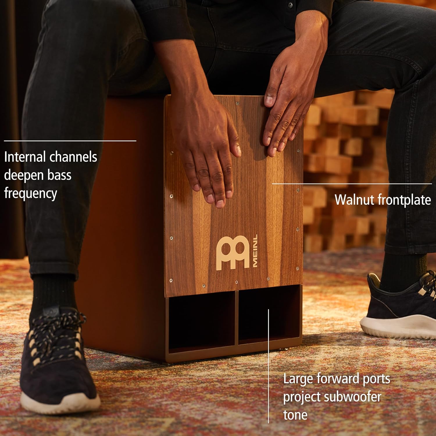 Homem tocando cajon Meinl com superfície de nogueira e canais internos para graves profundos.