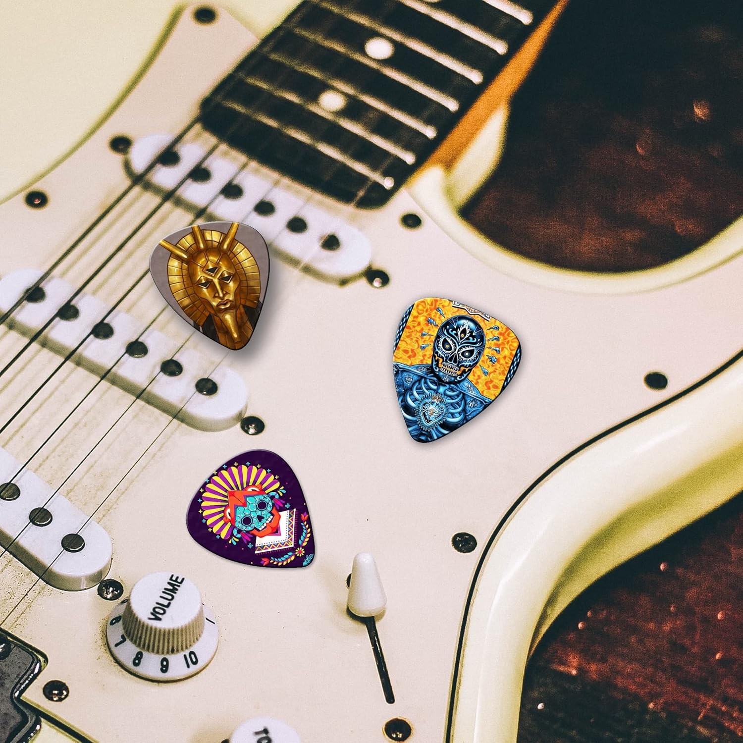 Palhetas coloridas para guitarra com designs artísticos sobre guitarra branca.