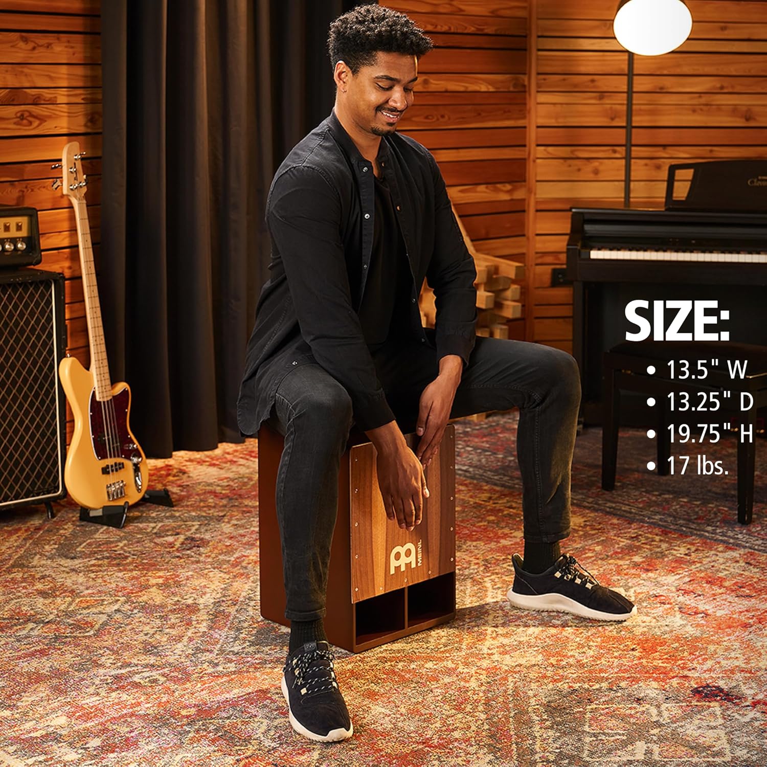 Dimensões e peso do cajon Meinl Jumbo Bass Subwoofer exibidas com homem tocando.