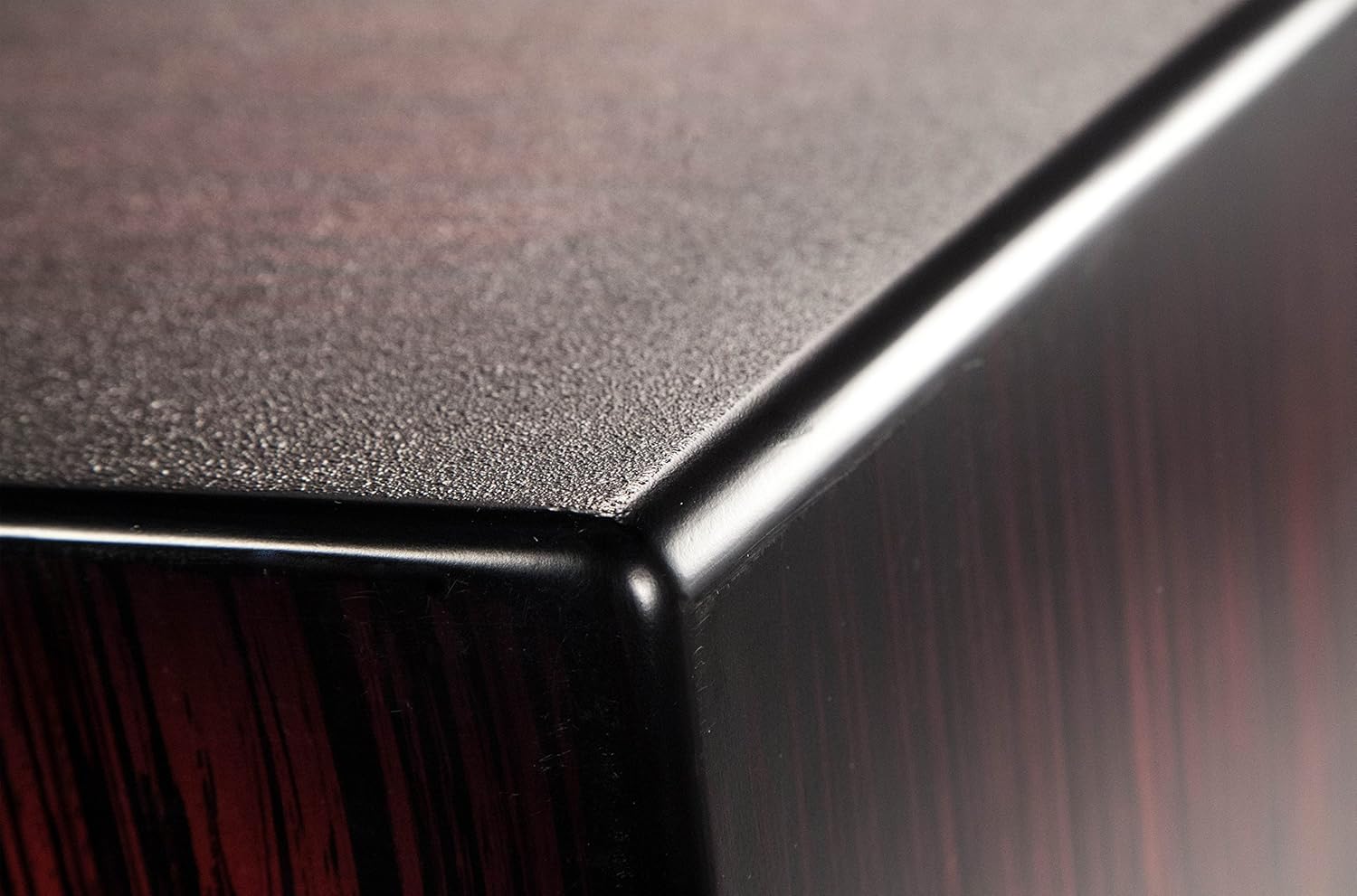 Canto superior do cajon LP Aspire Accents com acabamento preto fosco texturizado e madeira escura vermelha com listras pretas.