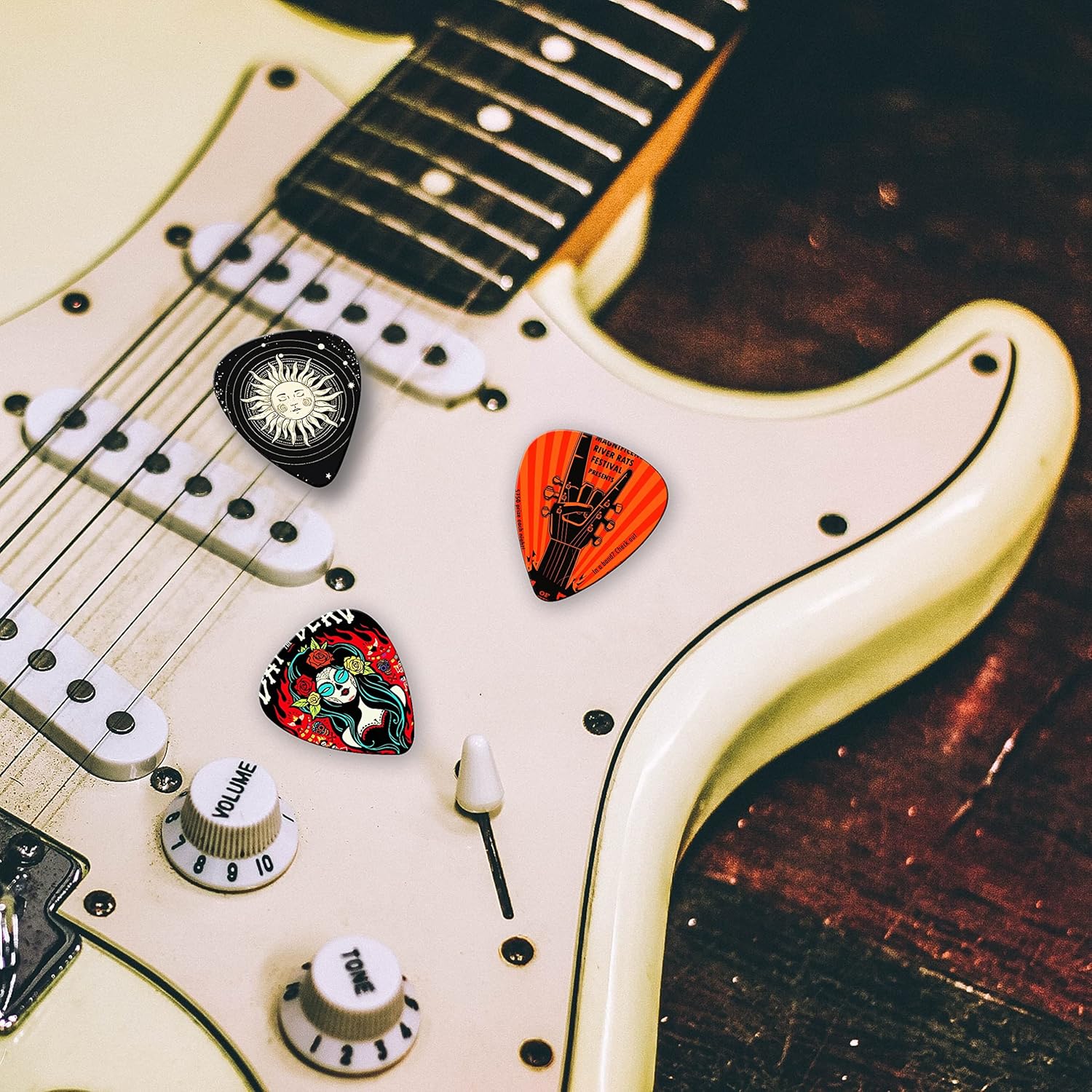 Palhetas coloridas para guitarra sobre guitarra elétrica branca.