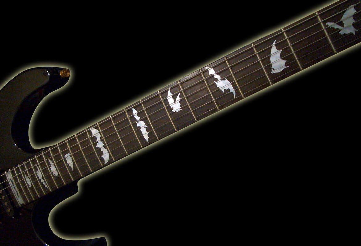 Guitarra preta com adesivos de morcego em pérola branca aplicados no braço.