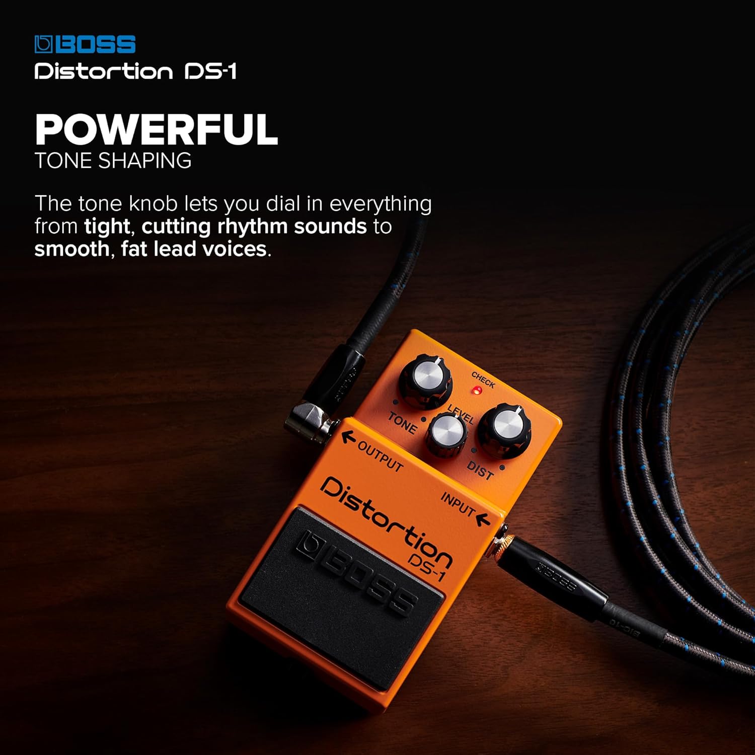 Pedal Boss DS-1 Distortion conectado com cabos sobre fundo de madeira escura